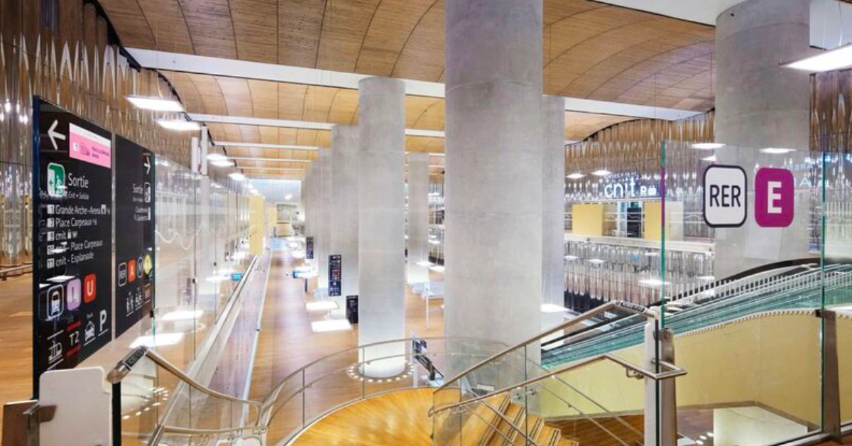Modern RER E railway station interior with platforms and passenger signage